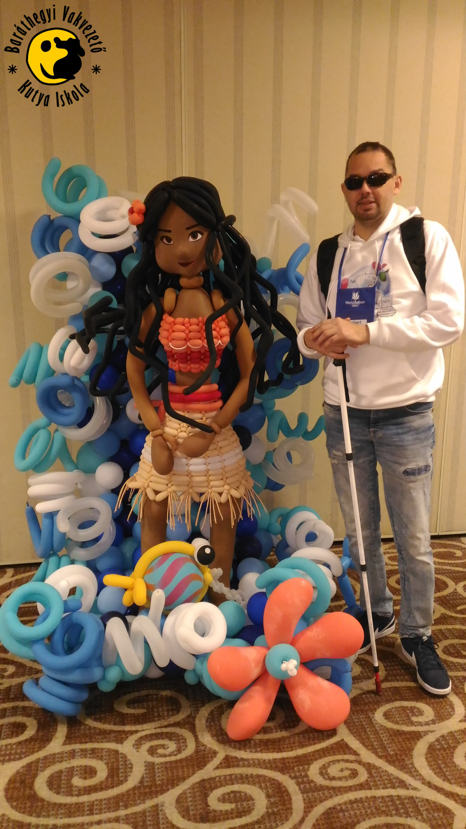 Norbert egy életnagyságú lufilánnyal, aki barna bőrű és csinos